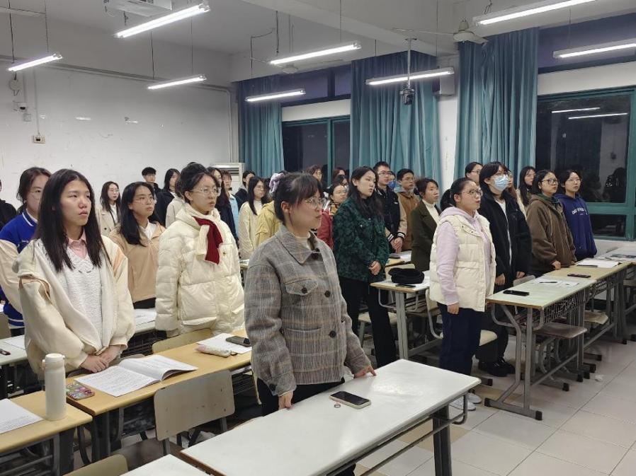图为全体起立奏唱国歌
