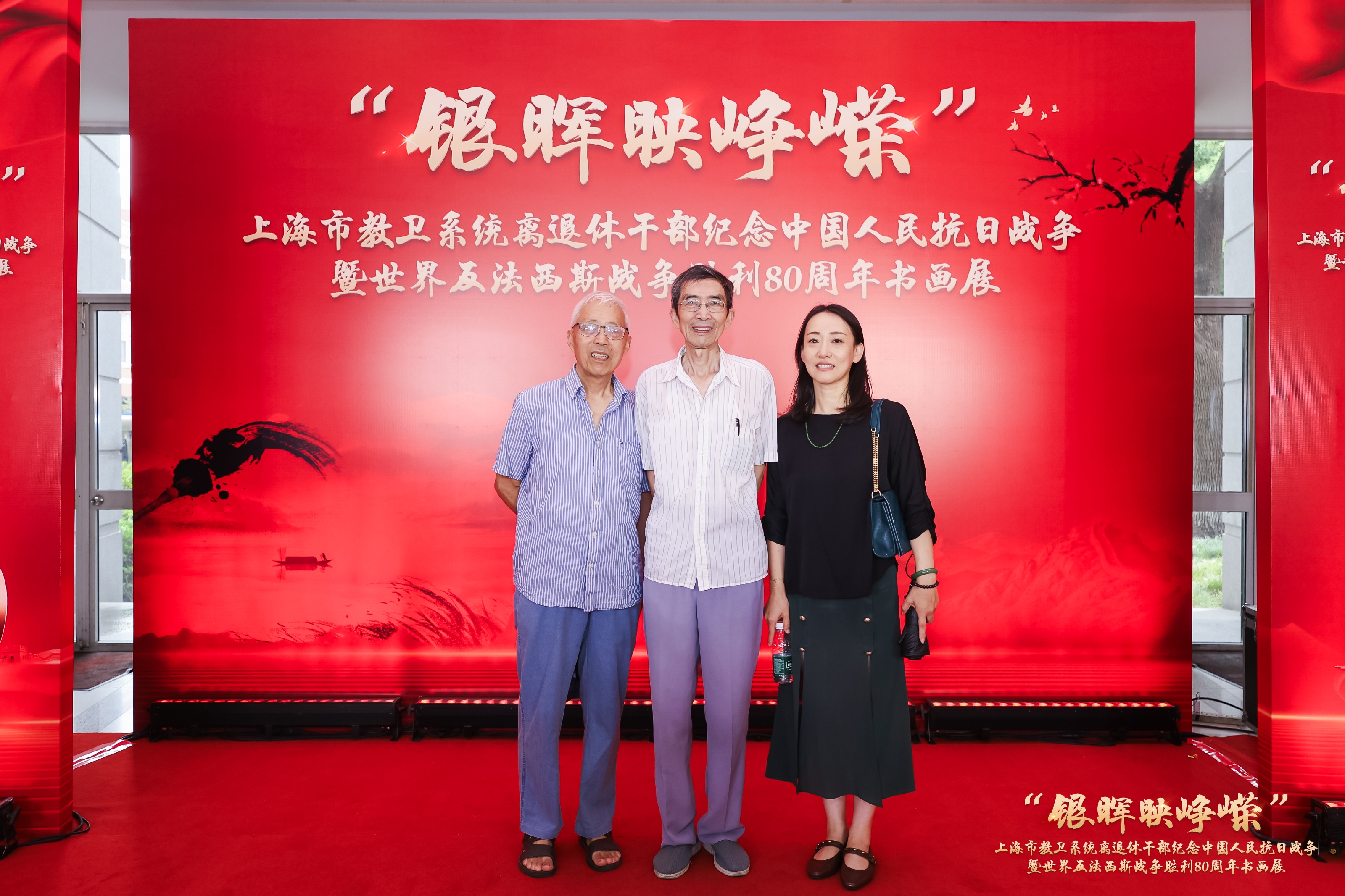 图为离退休党总支书记伊铭与离退休党员代表顾一平、沙立仁在上海市教卫系统“银晖映峥嵘”书画展开幕式上